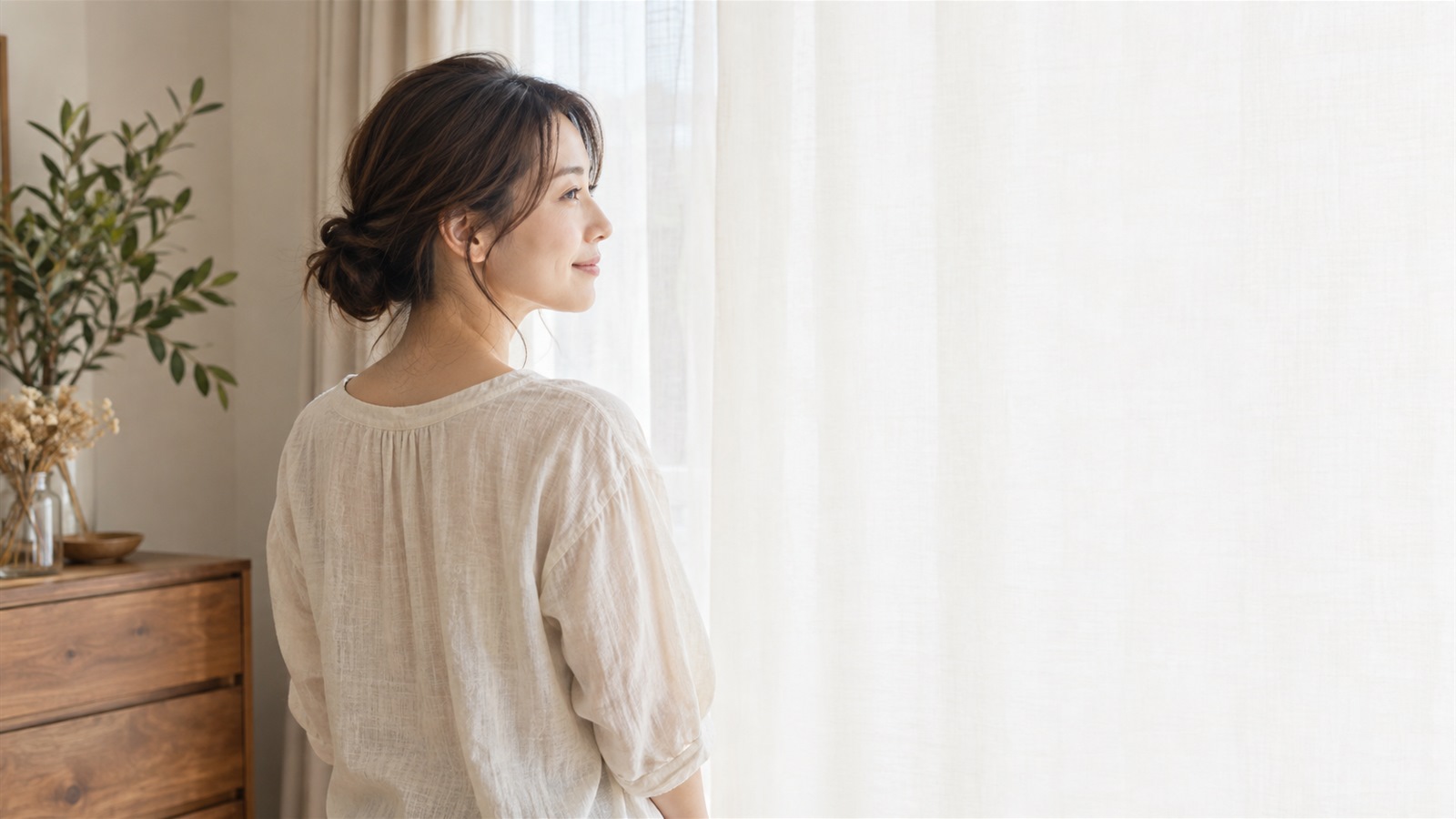 窓辺で穏やかに佇む女性